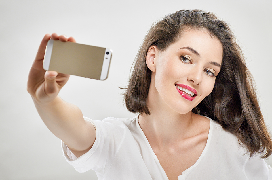 Mujer haciéndose un selfie con el móvil, para el artículo "probador virtual de maquillaje"