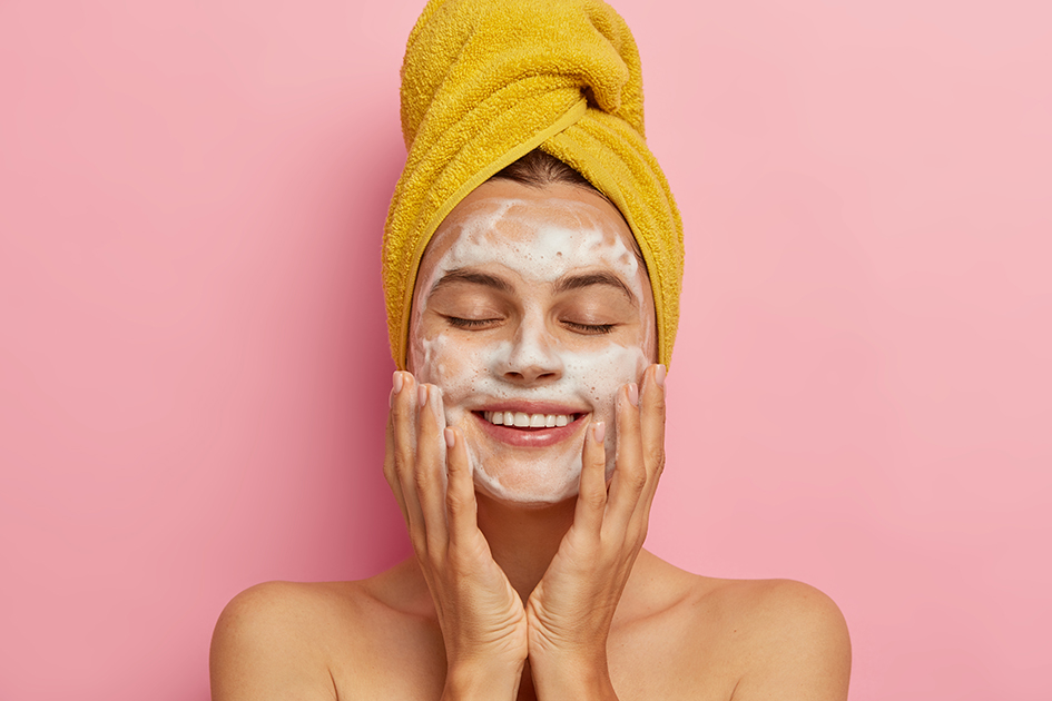 Chica realizando limpieza facial, con una toalla de baño en la cabeza: para el post el mejor limpiador facial de farmacia